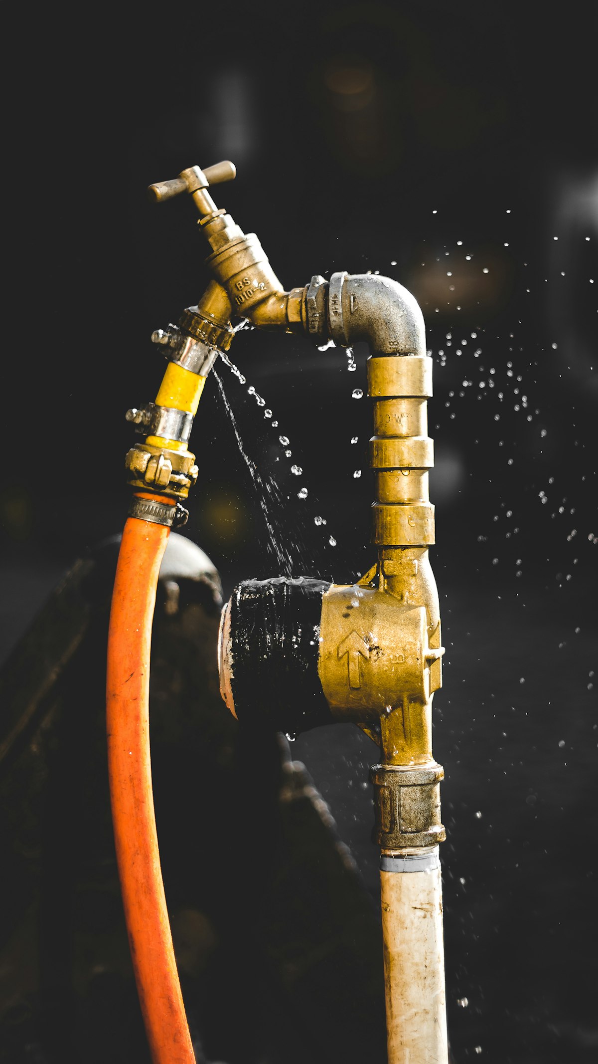 Plumber repairing a leaking pipe and shutoff valve