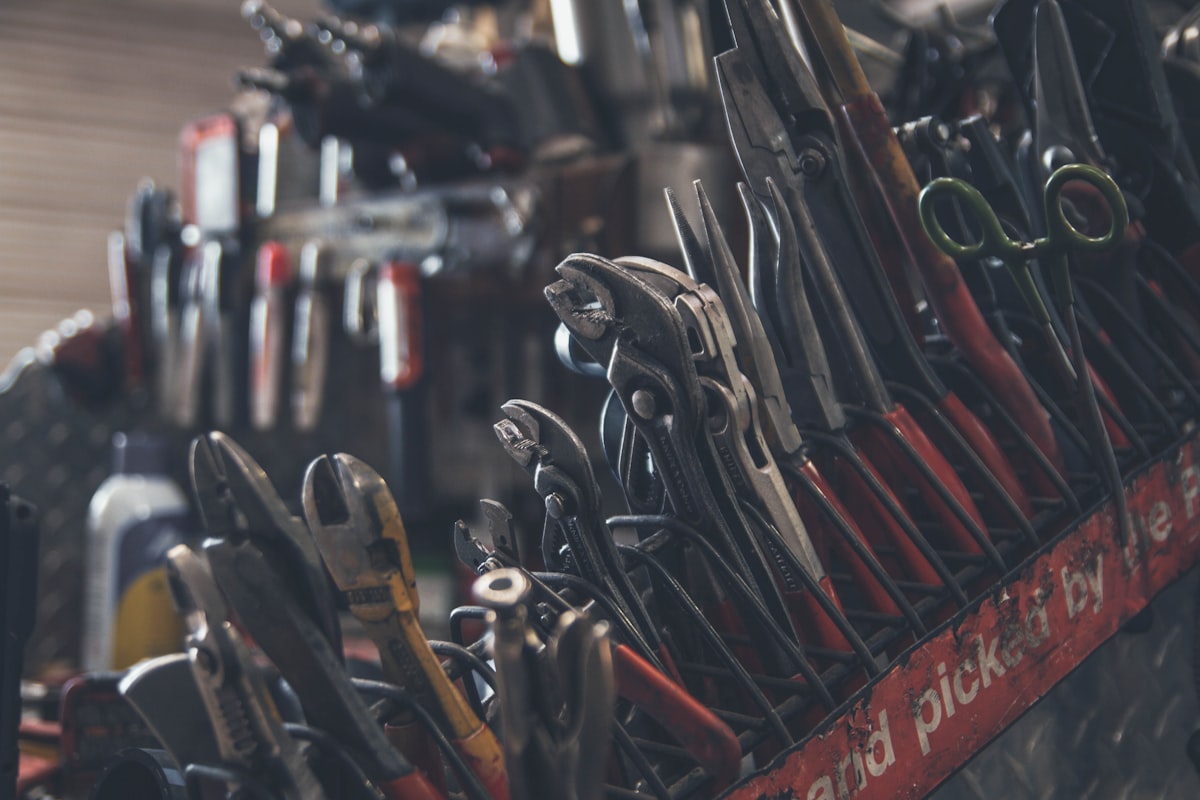 Rows of pliers and pipe wrenches hanging on a tool rack